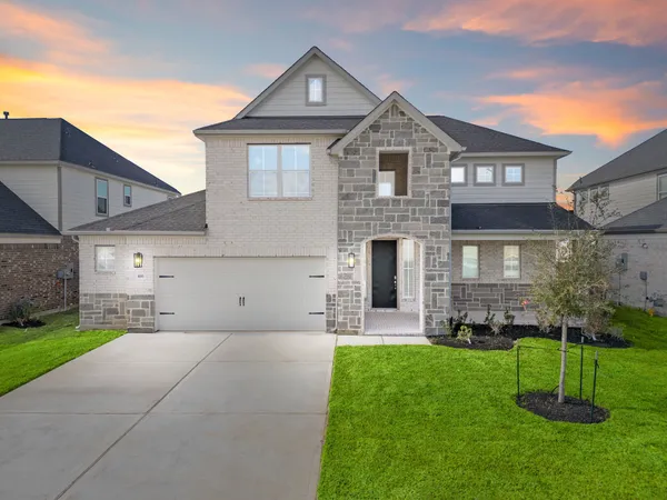 a front view of a house with a garden and plants
