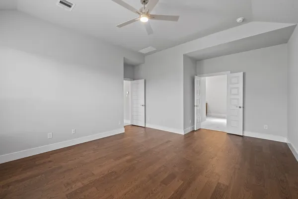 a view of an empty room with wooden floor