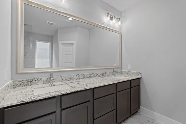 a bathroom with a granite countertop sink double and mirror