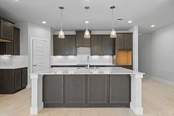 a kitchen with kitchen island a counter top space a sink and stainless steel appliances