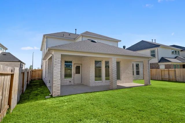 a view of a house with brick walls and a yard with windows