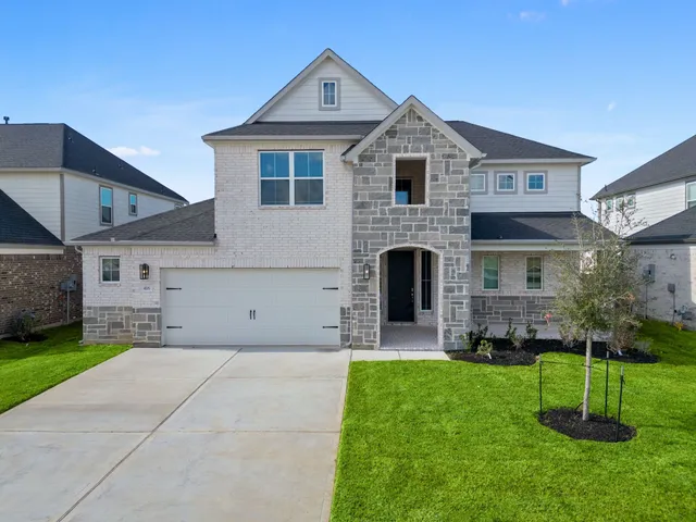 a front view of a house with a yard and trees