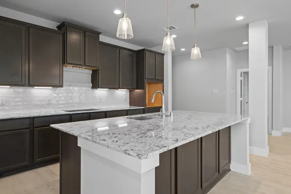 a kitchen with kitchen island granite countertop a sink a center island and cabinets