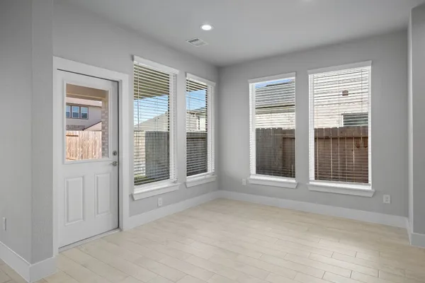 a view of an empty room with glass door and balcony