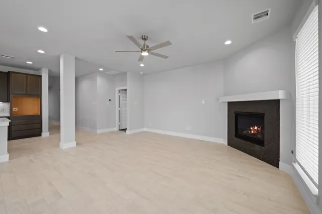 an empty room with a fireplace and fan