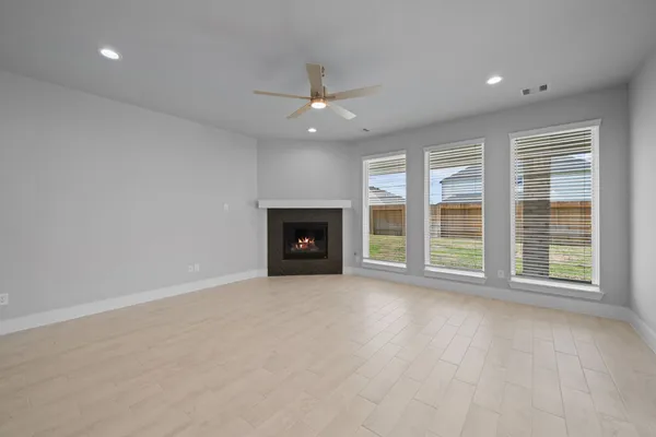 an empty room with windows and fireplace