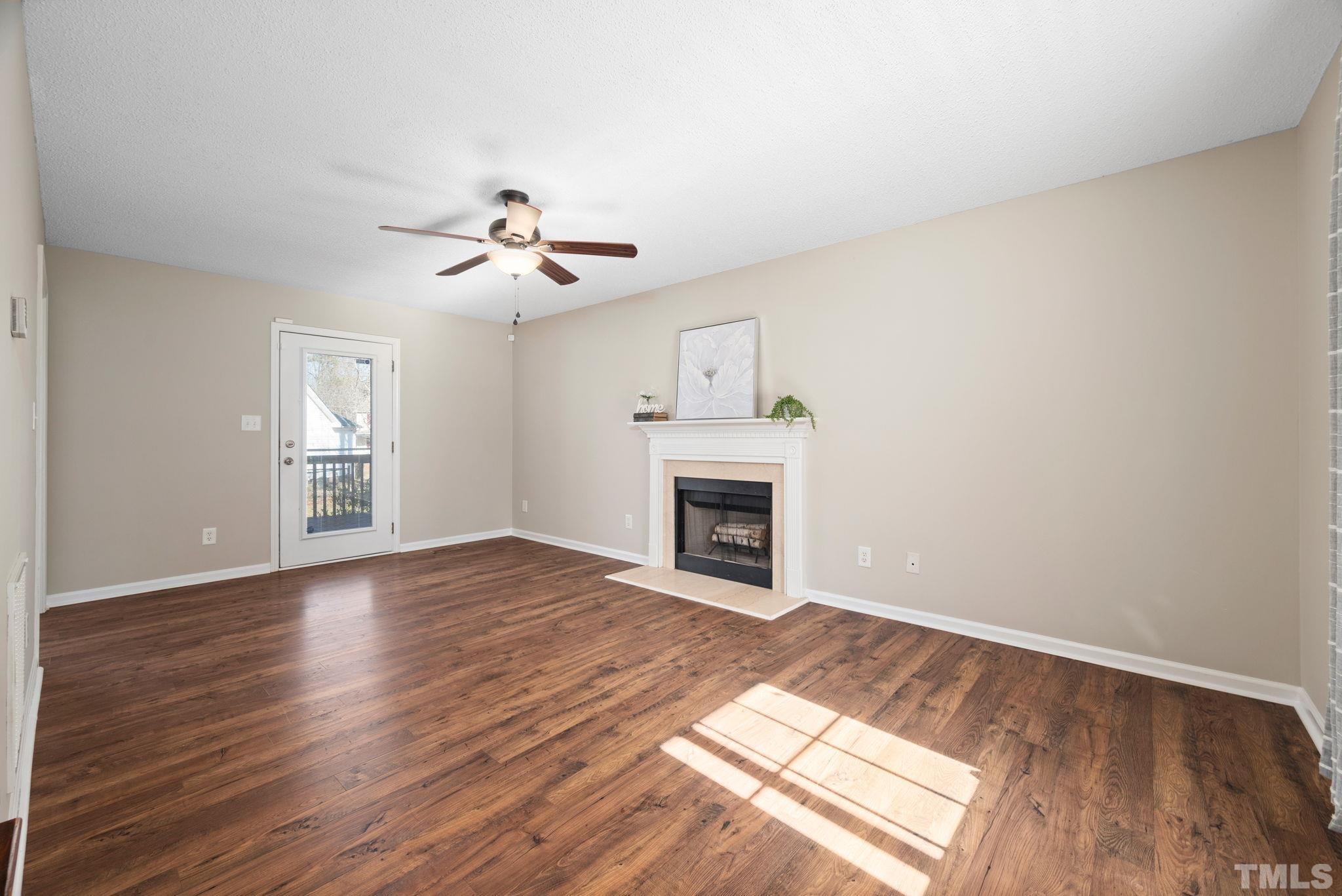 124 Gentle Rio Court Garner, NC 27529 - Photo 12 of 37 a view of an empty room with wooden floor fireplace and a window