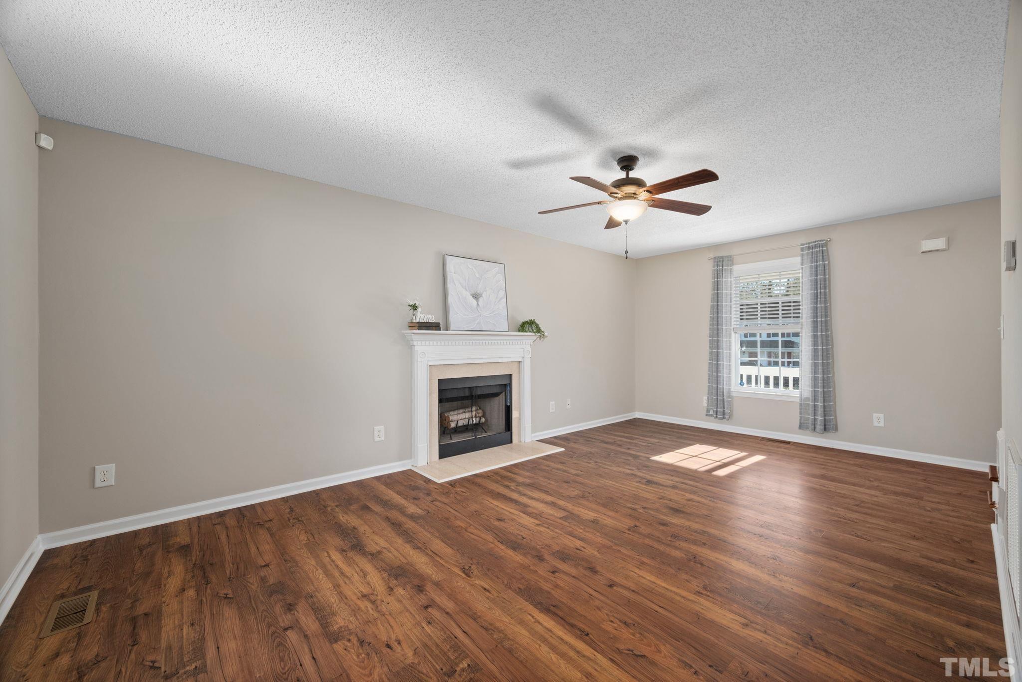 124 Gentle Rio Court Garner, NC 27529 - Photo 13 of 37 a view of an empty room with chandelier fan and wooden floor