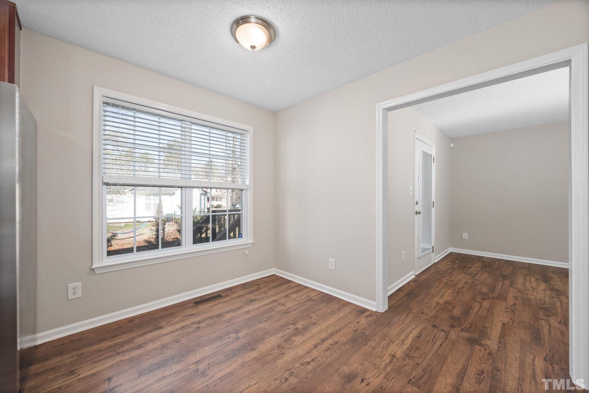 124 Gentle Rio Court Garner, NC 27529 - Photo 15 of 37 an empty room with wooden floor and windows