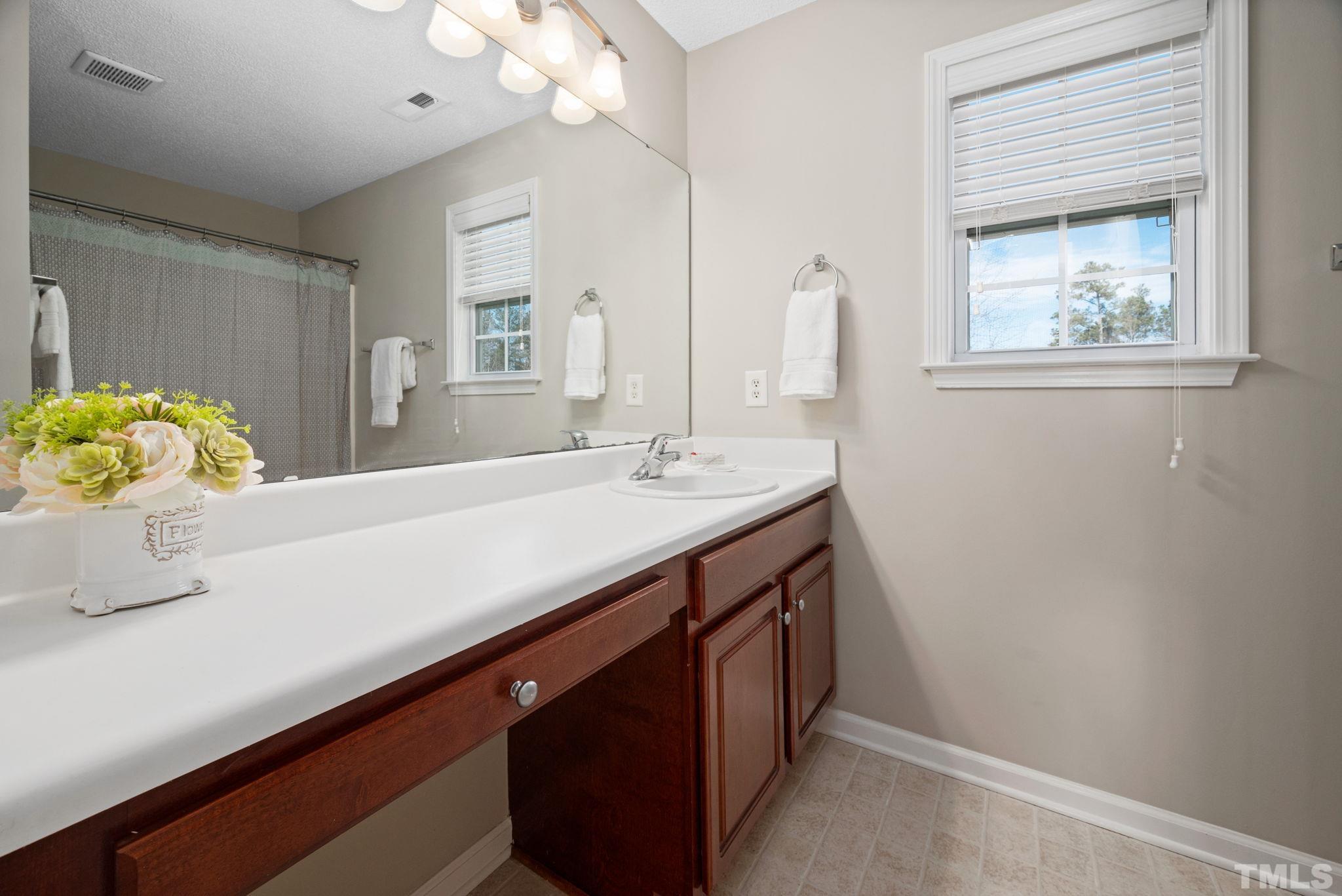 124 Gentle Rio Court Garner, NC 27529 - Photo 25 of 37 a bathroom with a sink a vanity and a mirror