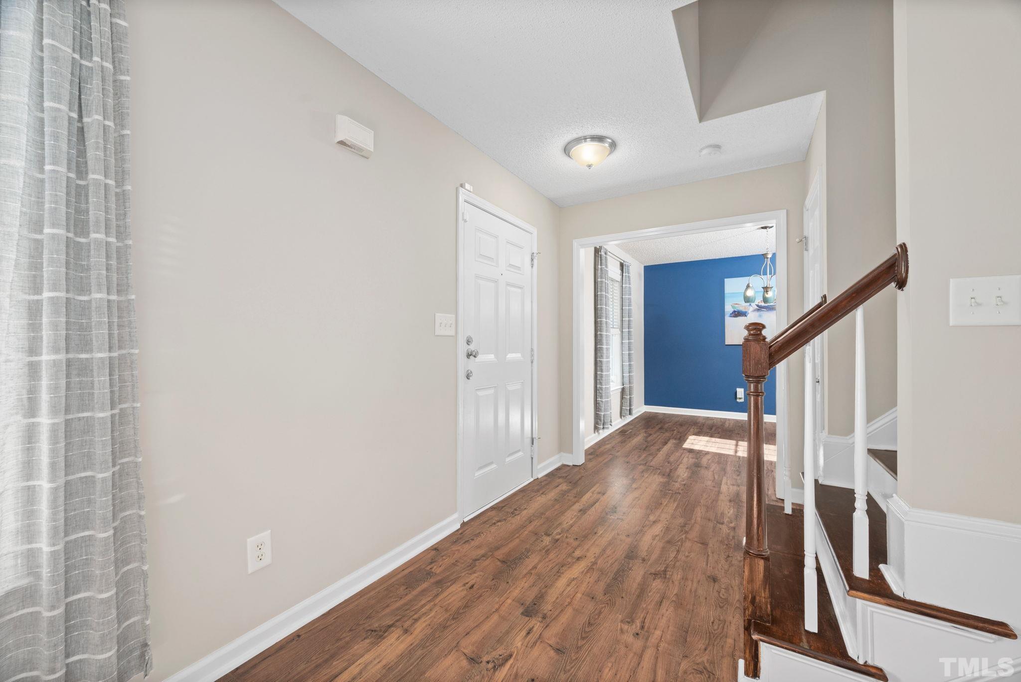 124 Gentle Rio Court Garner, NC 27529 - Photo 10 of 37 a view of a hallway view with wooden floor and staircase