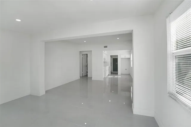 an empty room with windows and entrance to other room