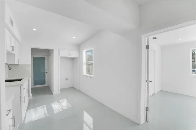 a kitchen with granite countertop white cabinets and stainless steel appliances