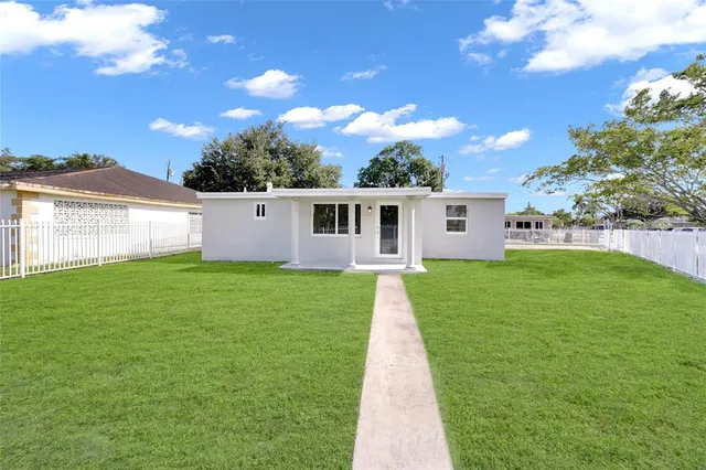 a front view of a house with a garden and yard