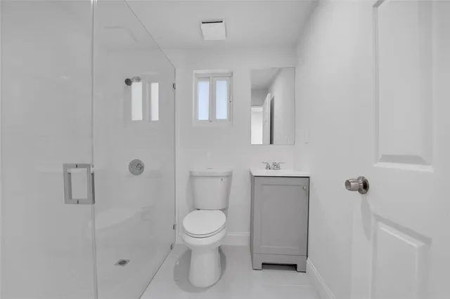 a bathroom with a toilet sink a mirror and shower