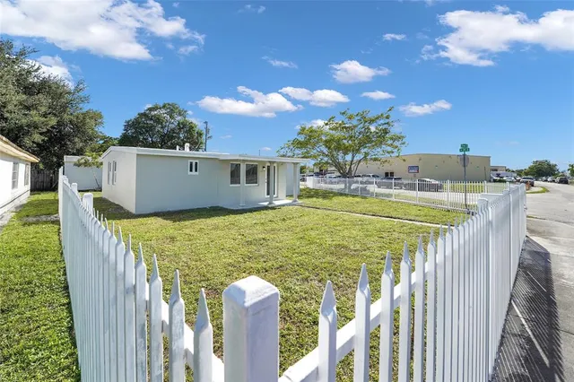 a front view of a house with a garden and yard