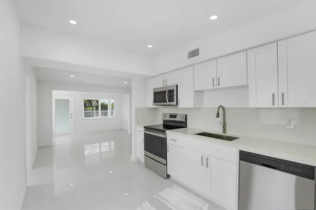 a kitchen with stainless steel appliances white cabinets and a sink