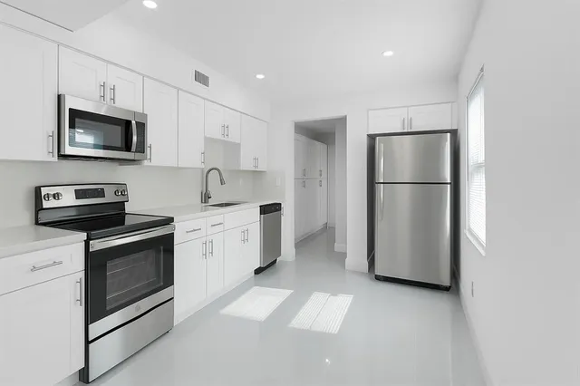a kitchen with cabinets stainless steel appliances and a counter space