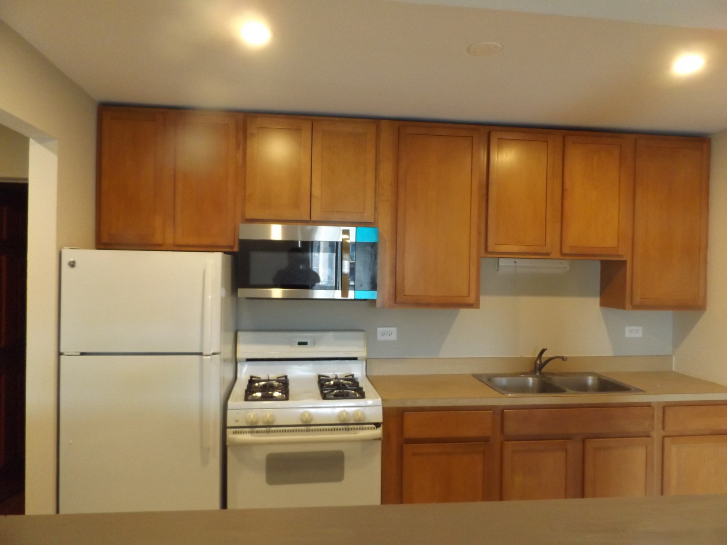 710 West Huntington Commons Road, Unit 3A Mount Prospect, IL 60056 - Photo 3 of 10 a kitchen with a sink a refrigerator and a stove top oven