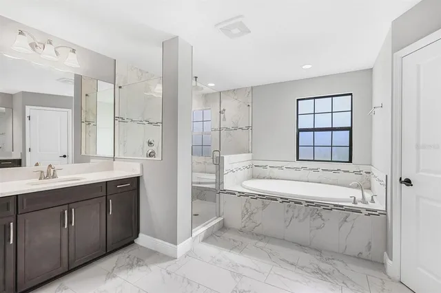 a spacious bathroom with a granite countertop sink a toilet and bathtub