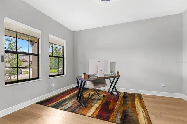 a view of a workspace with furniture and a window