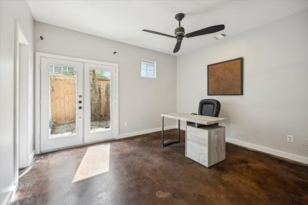 a view of a workspace with furniture and a window