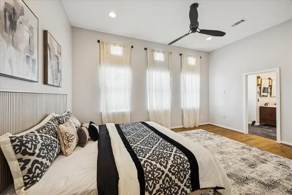 a bedroom with a large bed and a chandelier