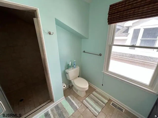 a bathroom with a toilet and a shower