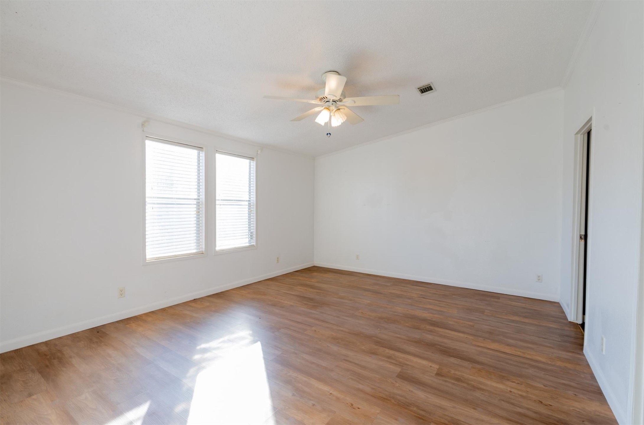 314 County Road 3577 Cleveland, TX 77327 - Photo 13 of 23 an empty room with wooden floor ceiling fan and windows