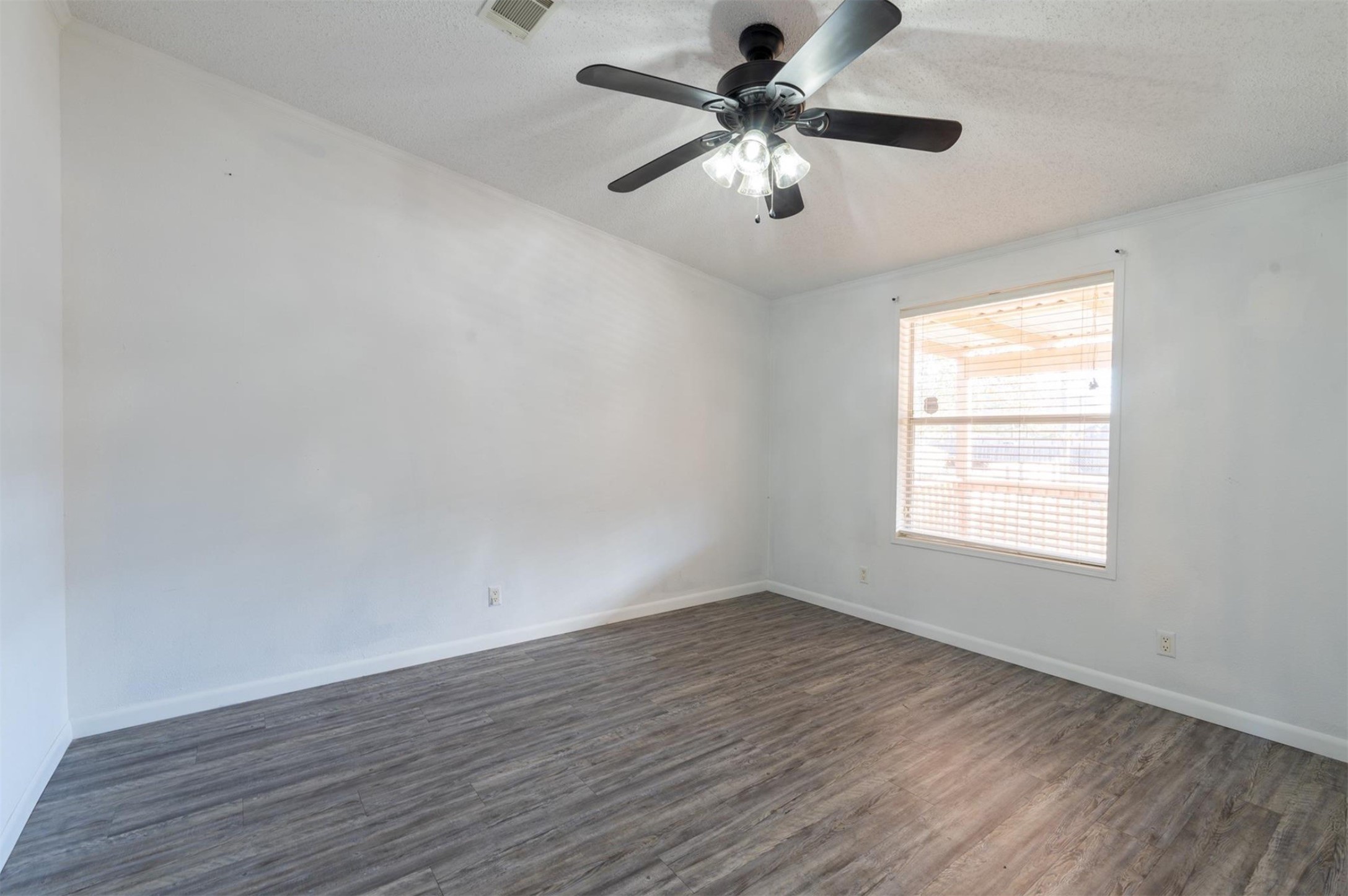 314 County Road 3577 Cleveland, TX 77327 - Photo 16 of 23 an empty room with wooden floor ceiling fan and windows