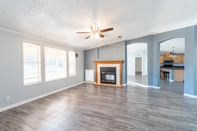 wooden floor fireplace and windows in an empty room