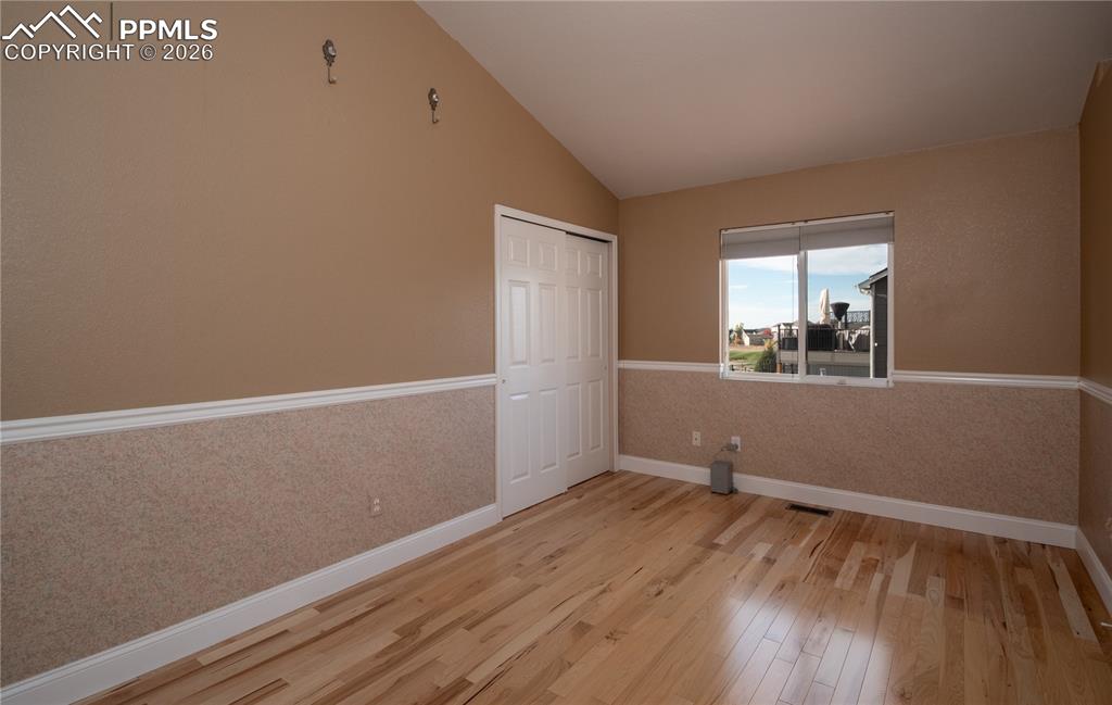 9385 Winged Foot Road Peyton, CO 80831 - Photo 16 of 50 an empty room with wooden floor and windows