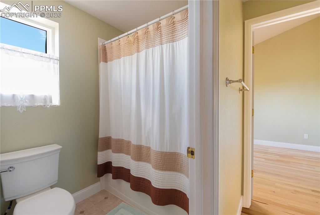 9385 Winged Foot Road Peyton, CO 80831 - Photo 23 of 50 a white toilet sitting next to a shower curtain