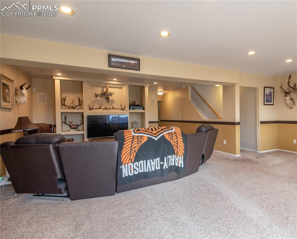 9385 Winged Foot Road Peyton, CO 80831 - Photo 26 of 50 a living room with furniture a kitchen view and a wooden floor