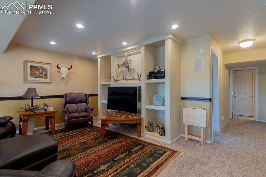 9385 Winged Foot Road Peyton, CO 80831 - Photo 27 of 50 a living room with furniture a flat screen tv and a fireplace
