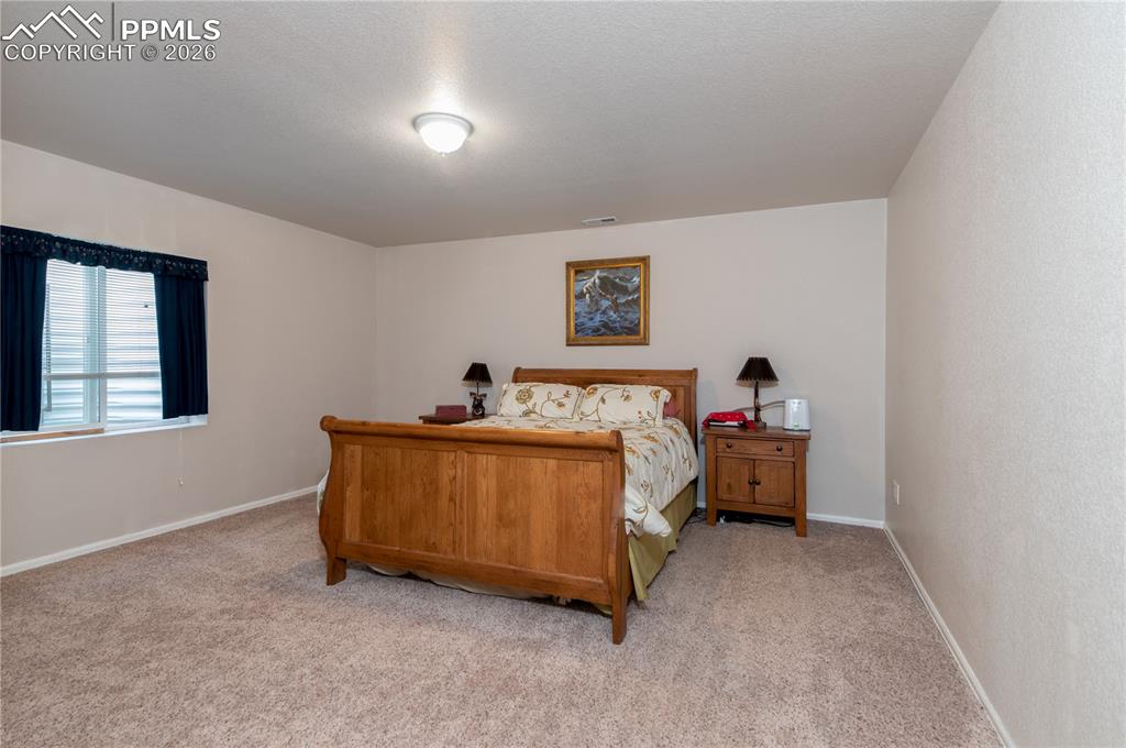 9385 Winged Foot Road Peyton, CO 80831 - Photo 32 of 50 a bed room with a bed and a couch