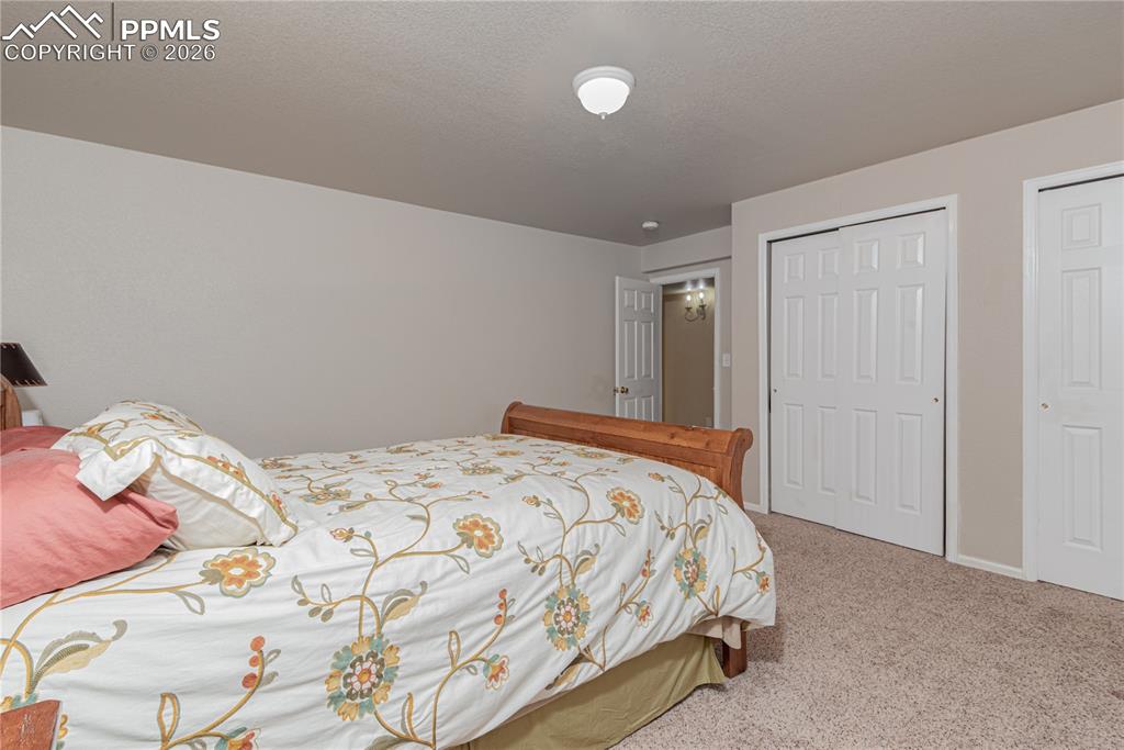 9385 Winged Foot Road Peyton, CO 80831 - Photo 33 of 50 a bedroom with a bed and a painting on the wall