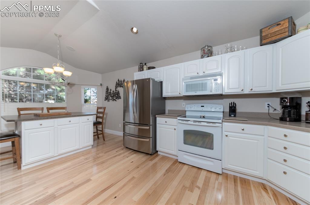 9385 Winged Foot Road Peyton, CO 80831 - Photo 5 of 50 a kitchen with white cabinets and white appliances