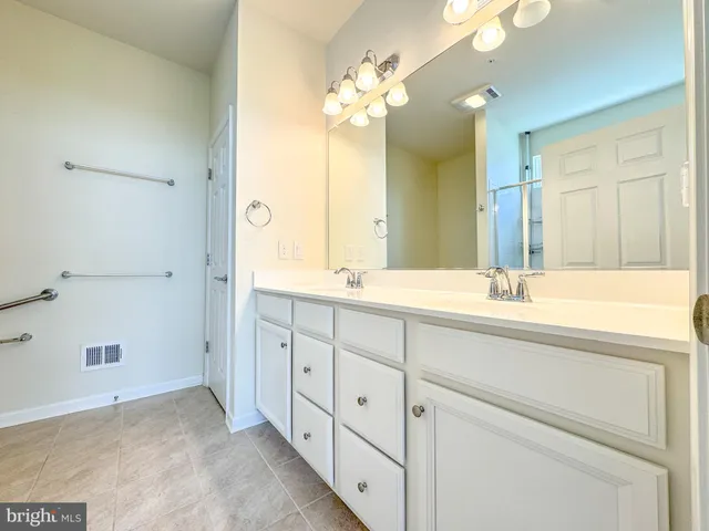 a bathroom with a double vanity sink and a mirror