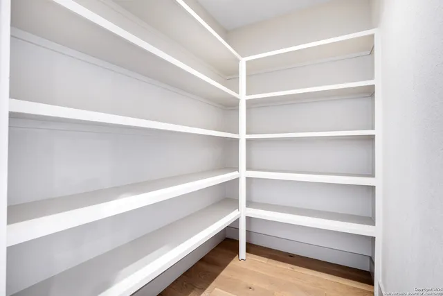 a view of walk in closet with empty racks