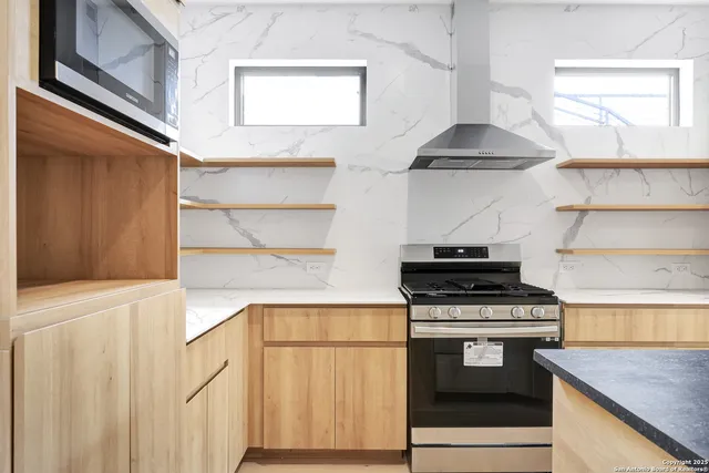 a kitchen with stainless steel appliances a stove and a microwave