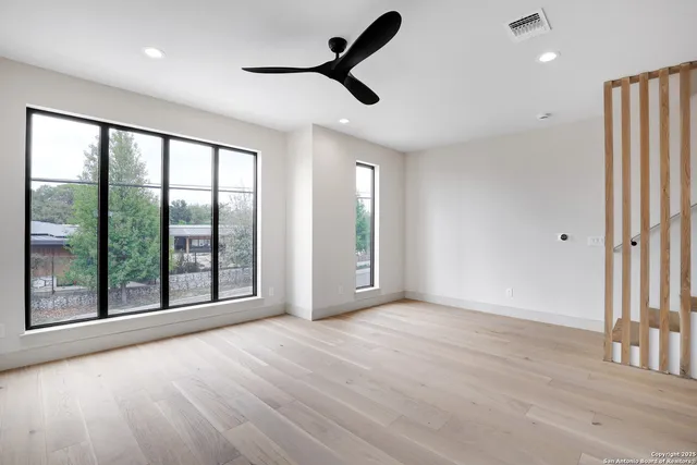 a view of an empty room with a window and wooden floor