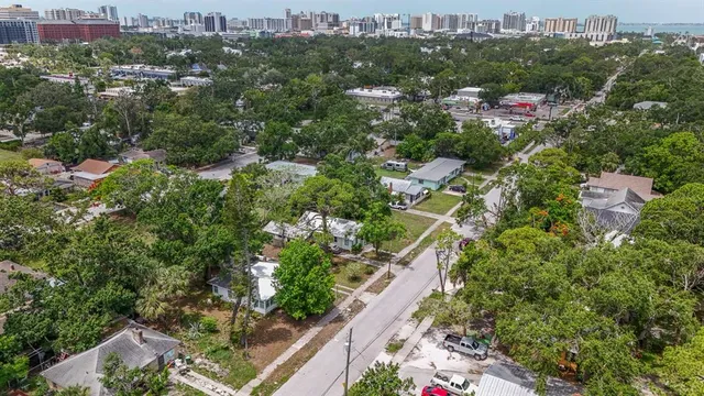 an aerial view of residential houses with outdoor space and trees