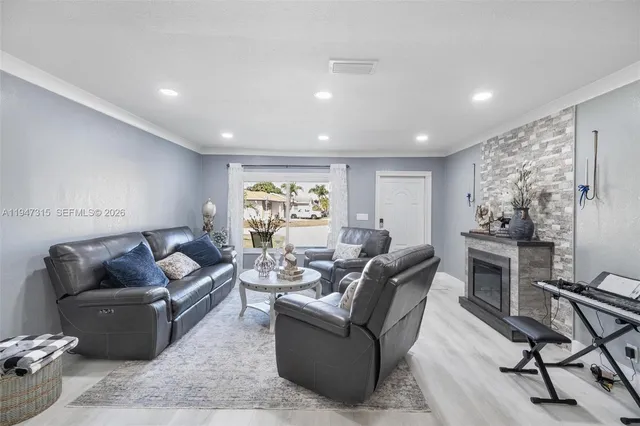 a living room with furniture a fireplace and a dining table with wooden floor