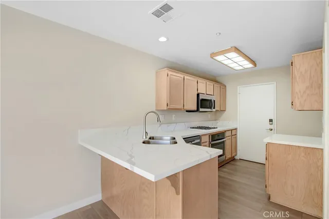 a kitchen with a sink cabinets and wooden floor