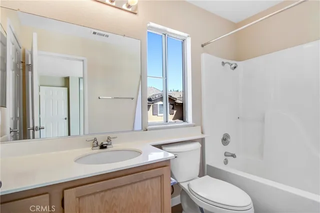 a bathroom with a toilet a sink a mirror a bathtub and shower