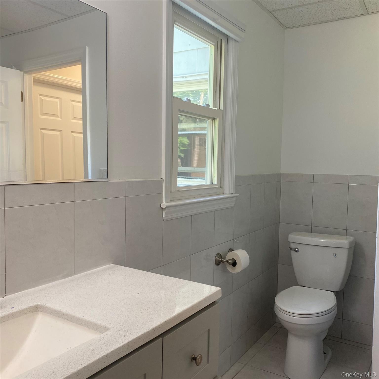 282 Laurel Road, Unit A East Northport, NY 11731 - Photo 11 of 20 a bathroom with a toilet a sink and a window