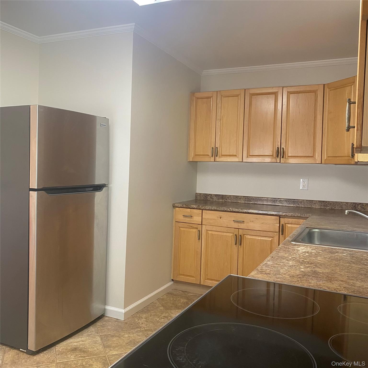 282 Laurel Road, Unit A East Northport, NY 11731 - Photo 7 of 20 a kitchen with a refrigerator and cabinets