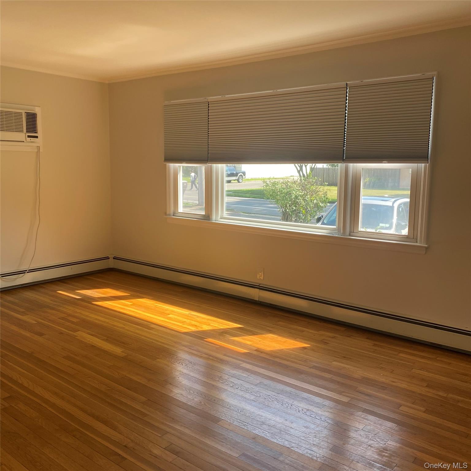 282 Laurel Road, Unit A East Northport, NY 11731 - Photo 8 of 20 an empty room with wooden floor and windows