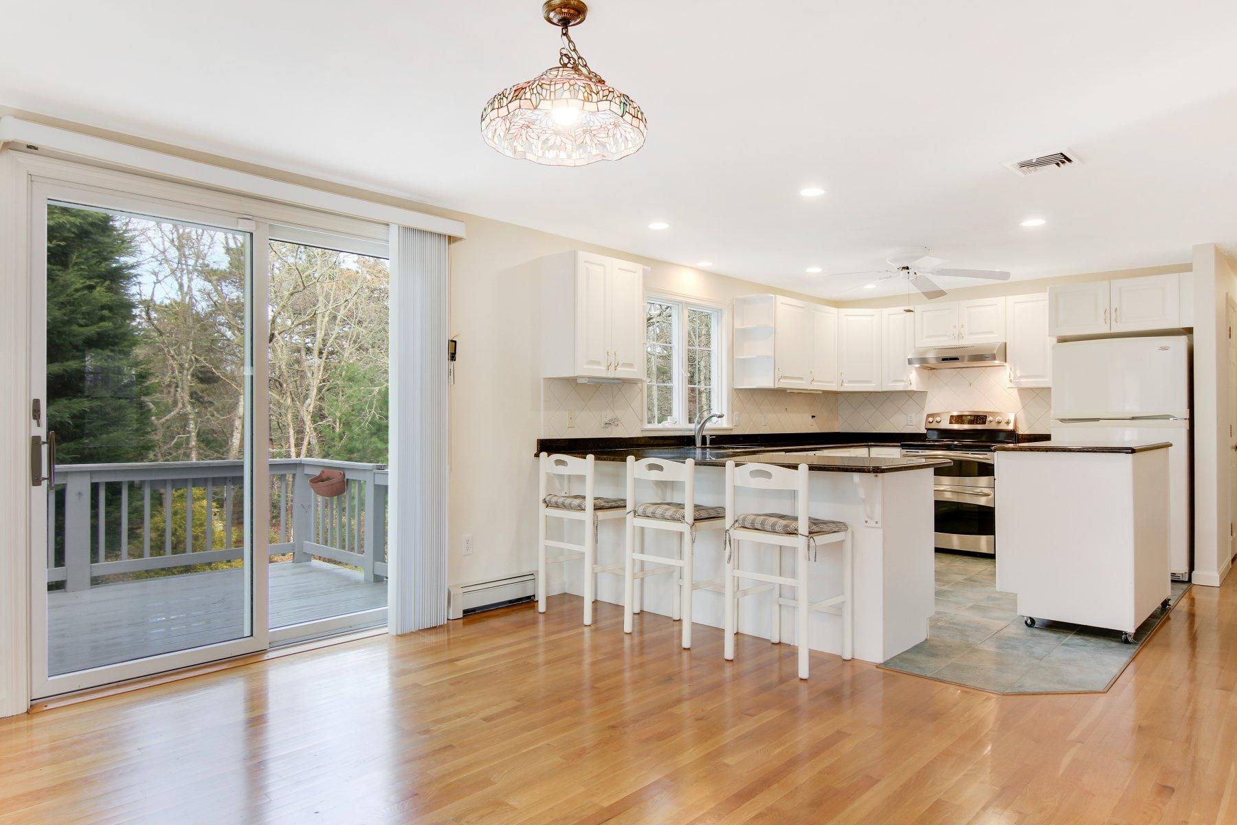 230 Chippingstone Road Chatham, MA 02633 - Photo 18 of 38 a kitchen with stainless steel appliances granite countertop a stove top oven a refrigerator a sink and white cabinets with wooden floor